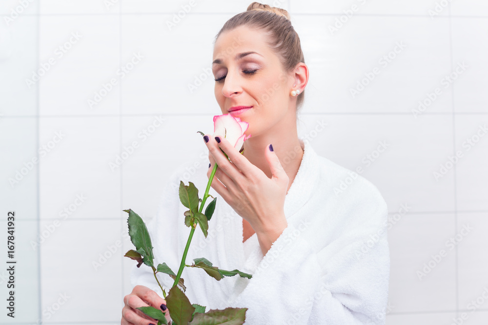 Woman in bathroom with bathrobe and white rose Woman in bathroom with bathrobe and white rose