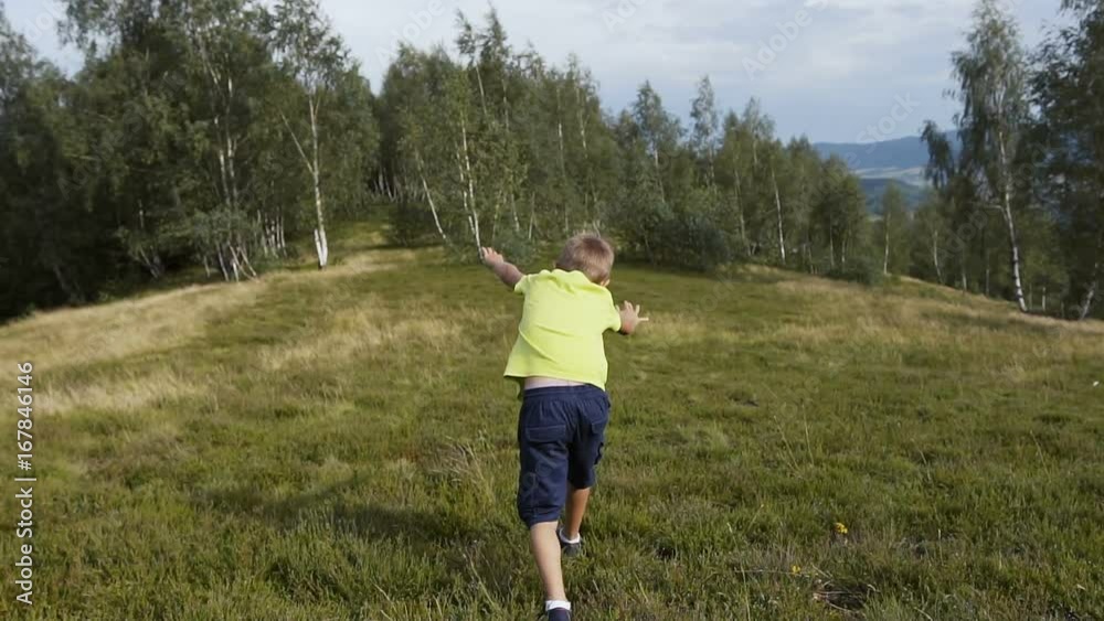 A boy gymnast runs and makes a somersault in the mountains A boy gymnast runs and makes a somersault in the mountains