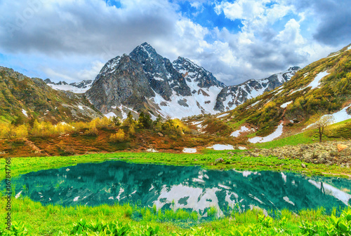 Lake in the mountains of Arkhyz. The beautiful summer landscape with snowy mountain and lake.
