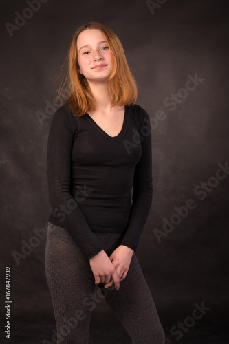 Portrait of a pretty young smiling redhead girl wear dark clothes