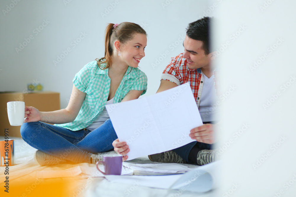 Young couple sitting on floor and calculating about they savings. Young couple Young couple sitting on floor and calculating about they savings. Young couple