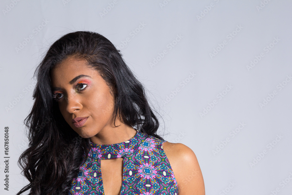 Young woman looks suspiciously aside. Black brazilian girl wearing summer dress.. Young woman looks suspiciously aside. Black brazilian girl wearing summer dress..