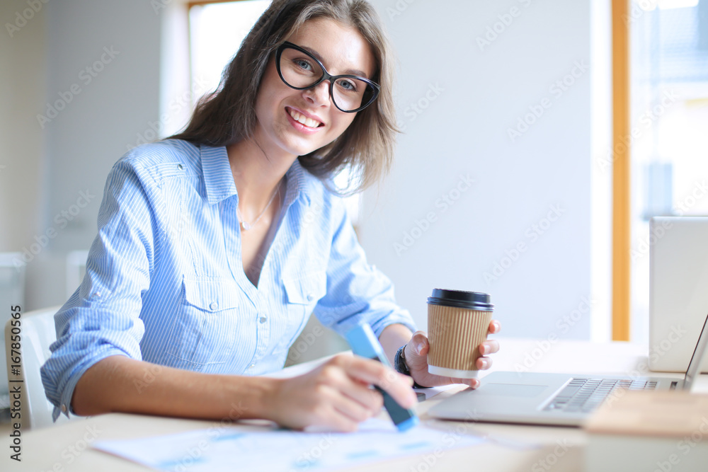 Young woman sitting in office table, looking at laptop computer screen . Young woman Young woman sitting in office table, looking at laptop computer screen . Young woman