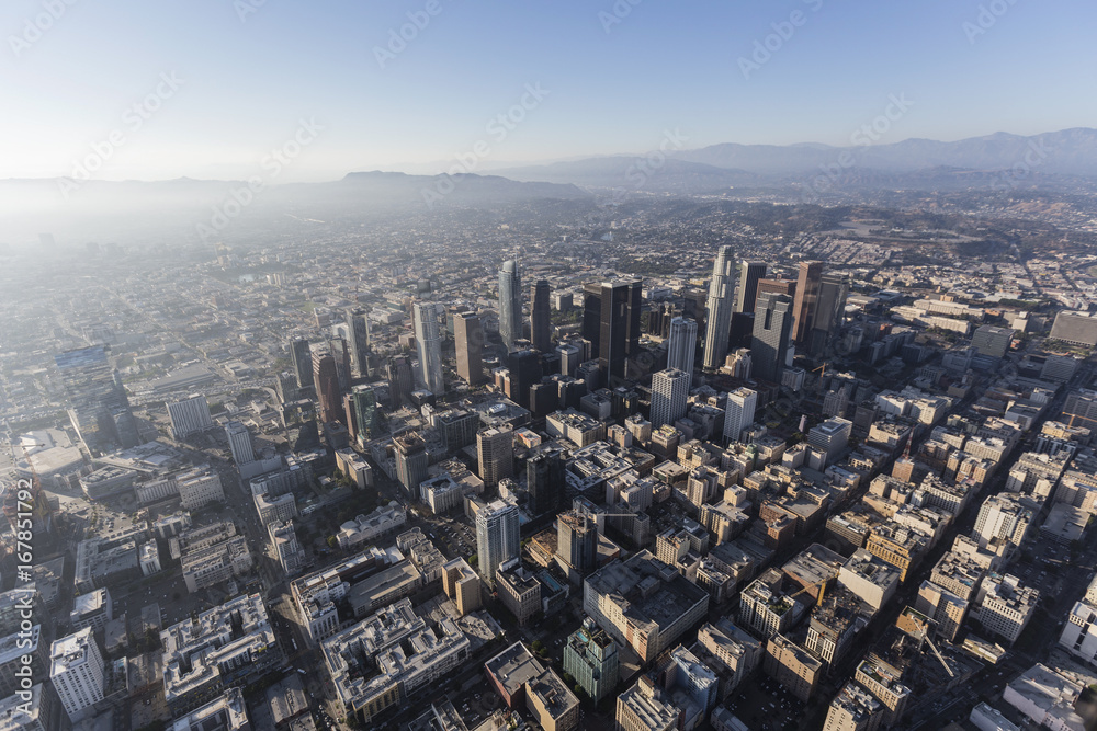 Hazy afternoon aerial view of urban downtown streets and buildings in Los Angeles, California. 