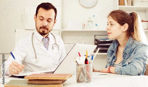 Doctor and girl with sore throat