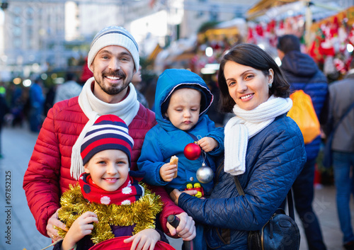 Parents with kids choosing X-mas decorations in market