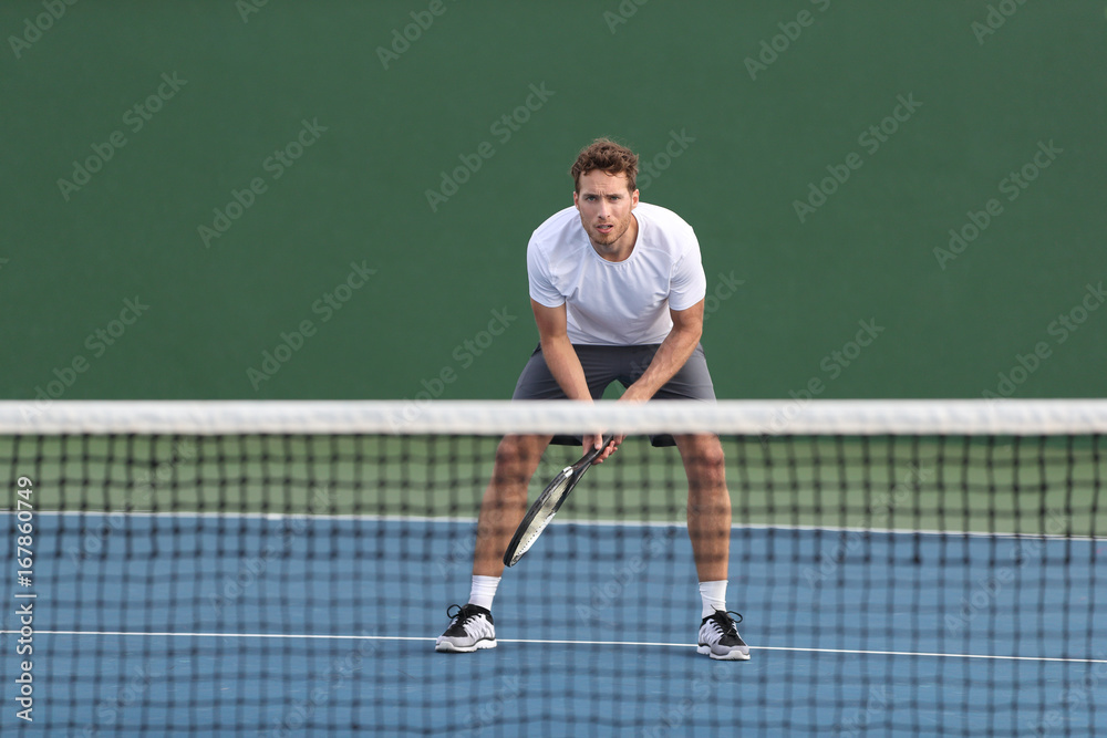 Professional tennis player man athlete waiting to receive ball, playing game on hard court. Fitness person focused behind net ready to return training cardio on outdoor sport activity.
