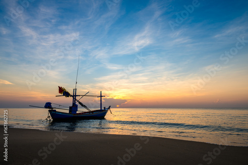 Sunrise on the sea beach with fishing boat © songdech17