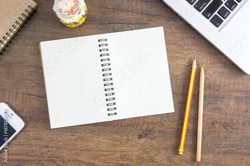 Top view notebook on wooden table with laptop, brown notebook, pencil for education and business. Lay down on brown wooden table.