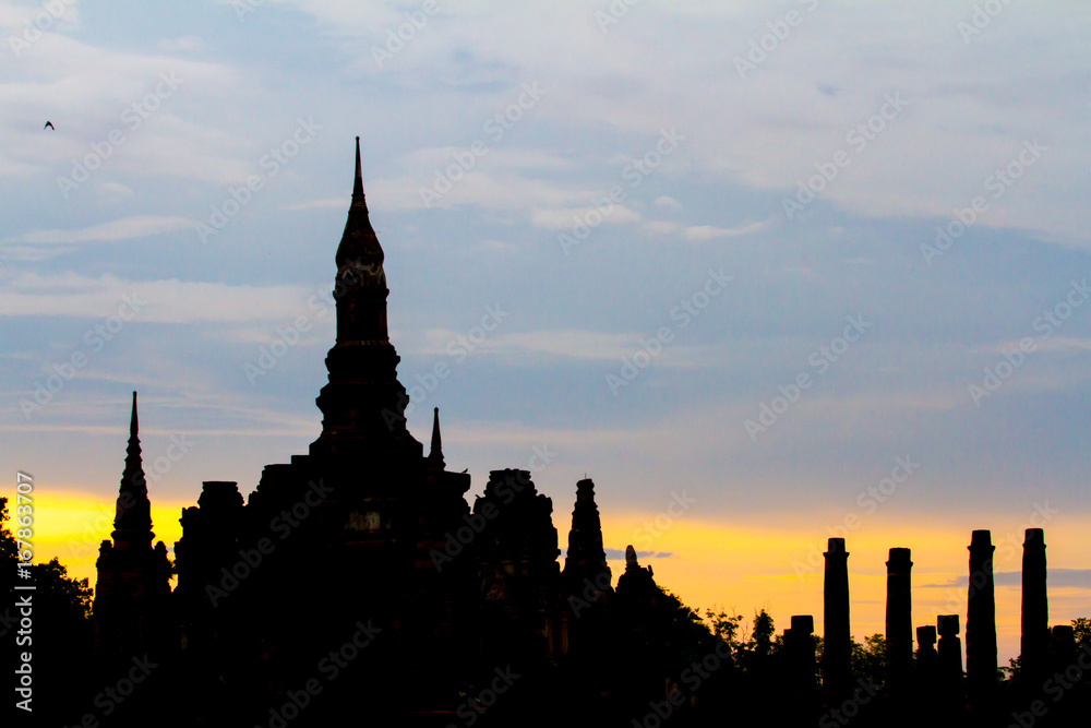 Naklejka premium Sukhothai Historical Park with sihouette sunset in Thailand. Famous historical park in Thailand. Sunset at the park.