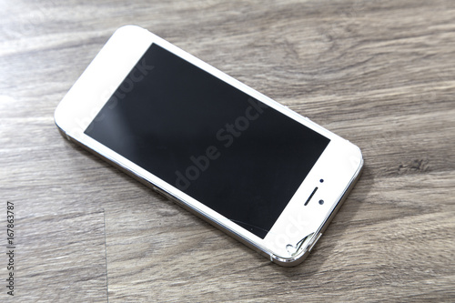 Mobile phone Bokeh screen on wood floor dark tone