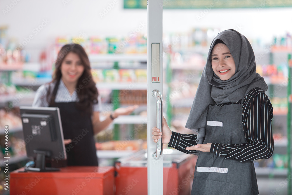 female opening the door welcoming customer female opening the door welcoming customer