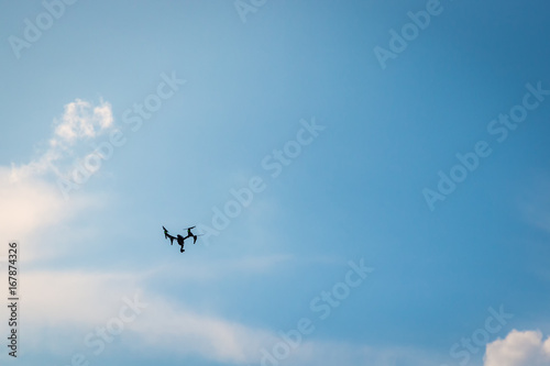 Drone hovering in a bright blue sky