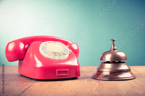 Retro telephone and hotel reception service desk bell. Old style filtered photo