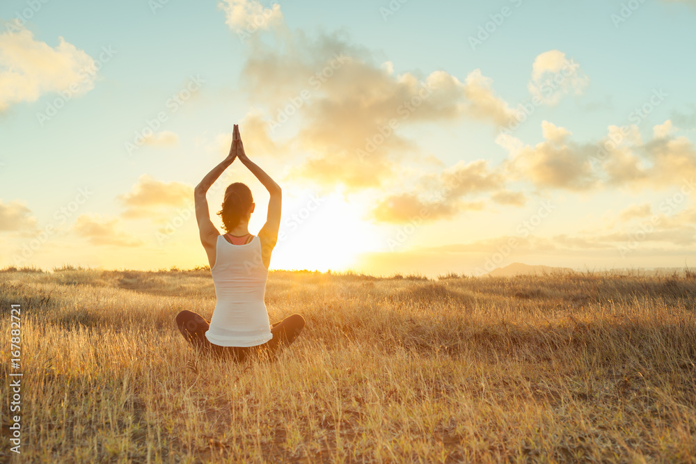 Woman doing yoga at sunset.  - obrazy, fototapety, plakaty 