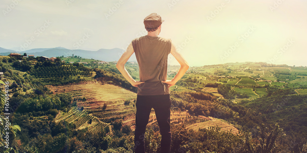 man looking vineyard at sunset, back view of proud person in a beautiful landscape