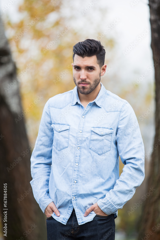 Handsome desolate man in the park. Autumn scenery Handsome desolate man in the park. Autumn scenery