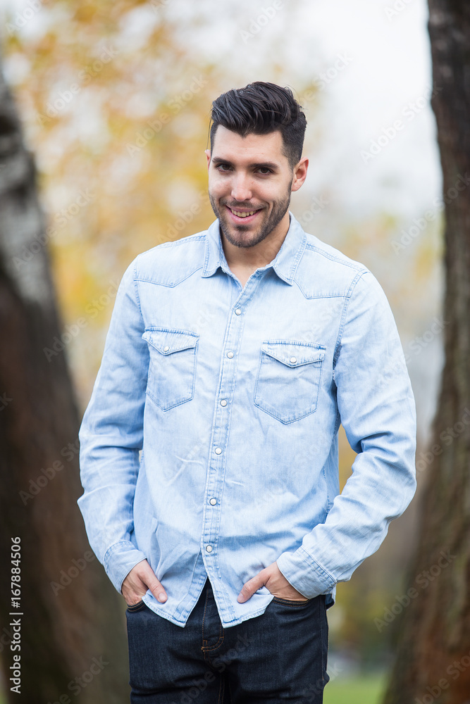 Handsome happy man in the park. Autumn scenery Handsome happy man in the park. Autumn scenery