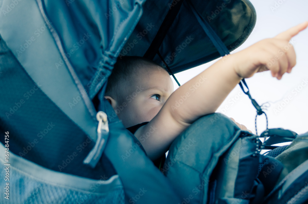 Travelling with a child. One year old child travelling in touristic baby carrier.