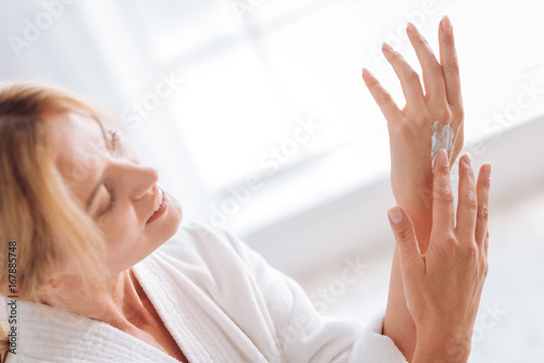 Profile photo of relaxed woman that applying cream