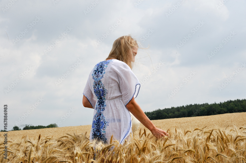 Frau im sommerlichen Kornfeld mit Kleid und Strohhut Frau im sommerlichen Kornfeld mit Kleid und Strohhut