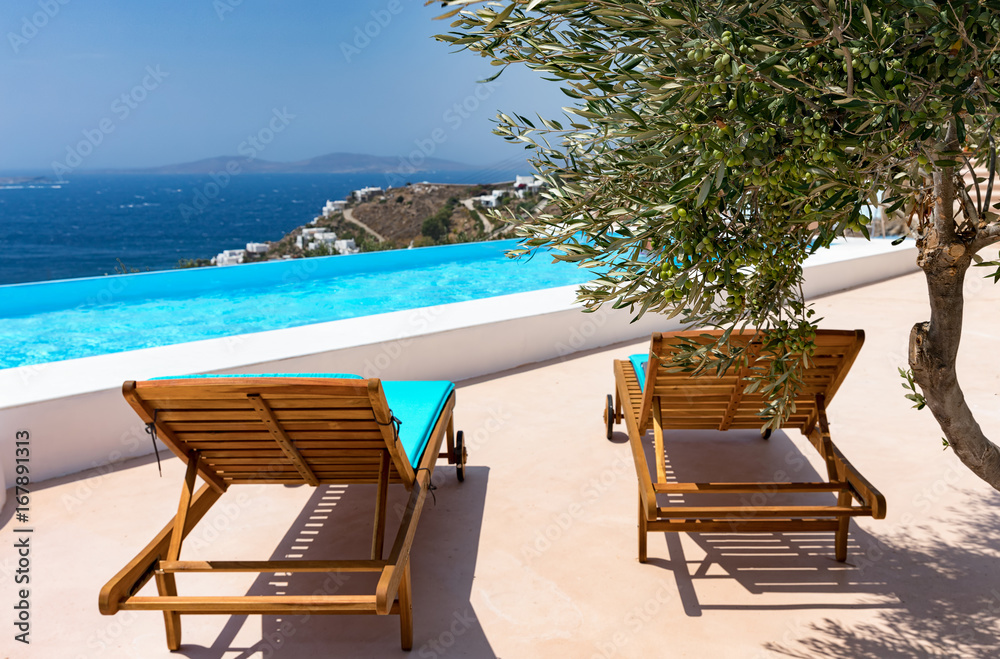 Mediterraner Hintergrund: Olivenbaum am Pool mit Liegestühlen