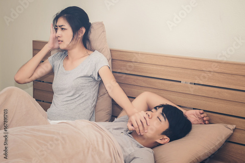 A woman has a nuisance to the man he loves sleeping loud snoring.Concept of life together