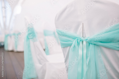Mint cloth decorates white chairs