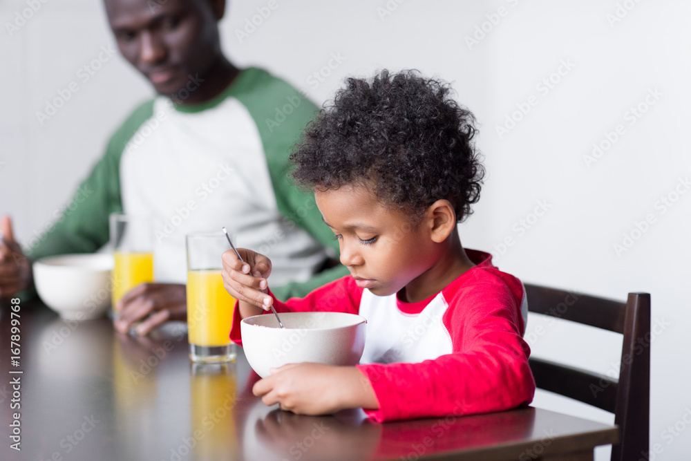father and son eating breakfast father and son eating breakfast