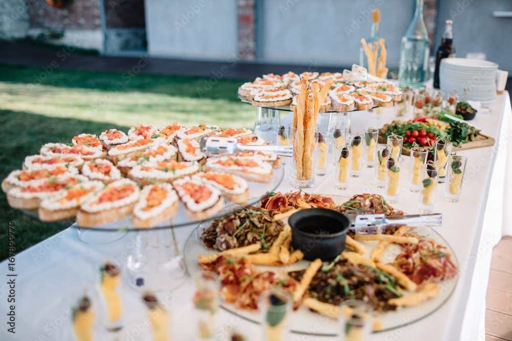 Long dinner table with delicious salty snacks