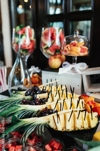 Pineapple with black sticks served on a large dish