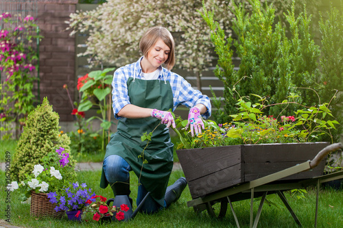 Young smiling woman florist working in the garden.