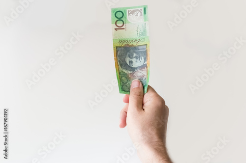 Man holding one hundred Australian Dollar note in his hand