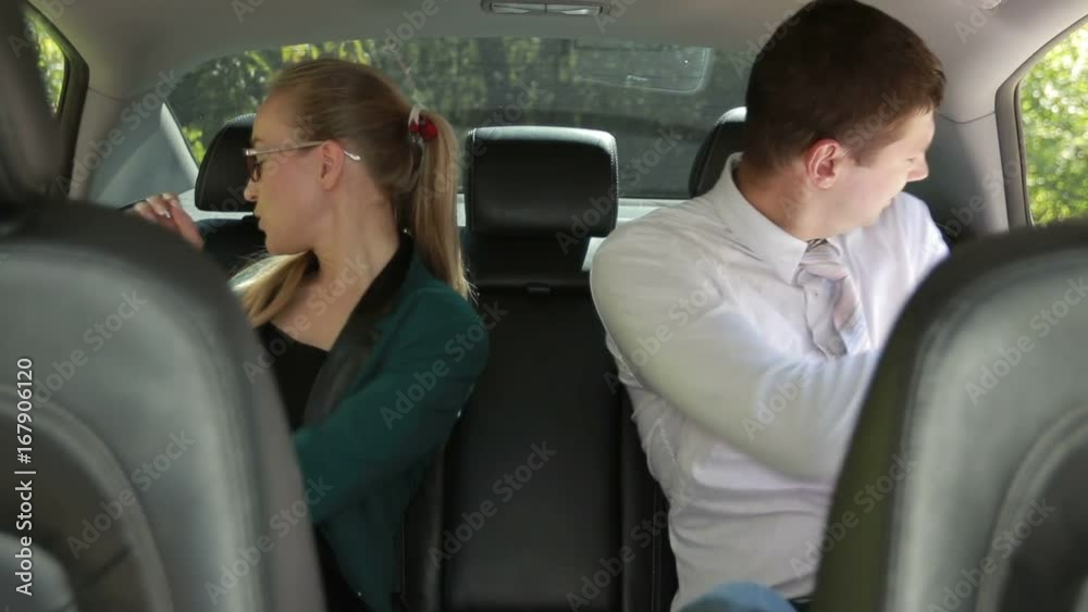 Business colleagues working at the backseat of car Business colleagues working at the backseat of car