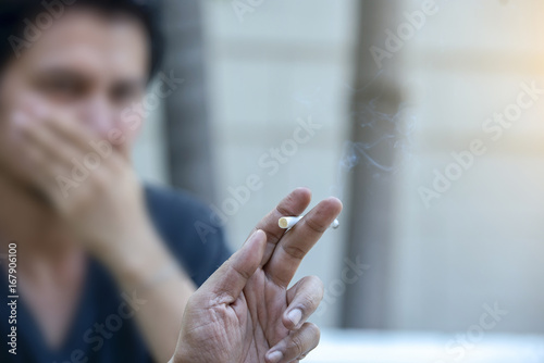 Passive smoking concept. Young man covering face from cigarette