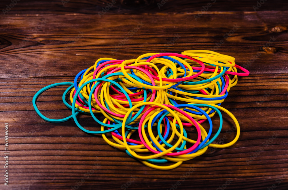 Multicolored rubber bands on wooden table Multicolored rubber bands on wooden table