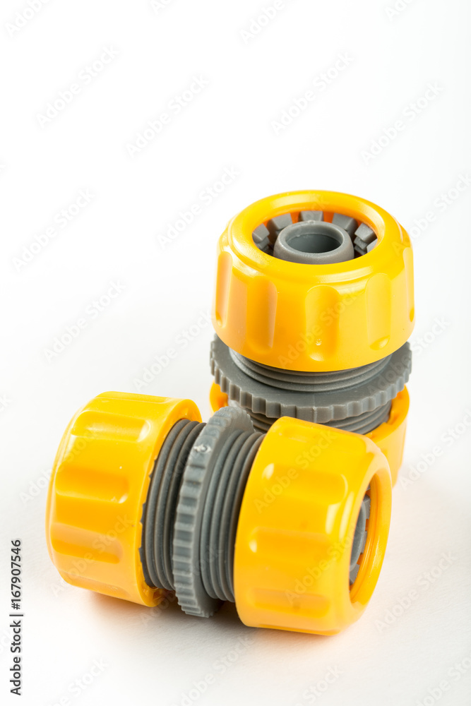Yellow plastic water hose connectors over white background Yellow plastic water hose connectors over white background