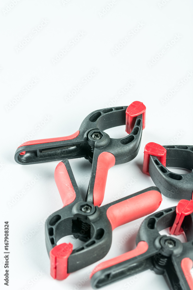 Red and black plastic carpenters pinch tools with copy space over white background Red and black plastic carpenters pinch tools with copy space over white background