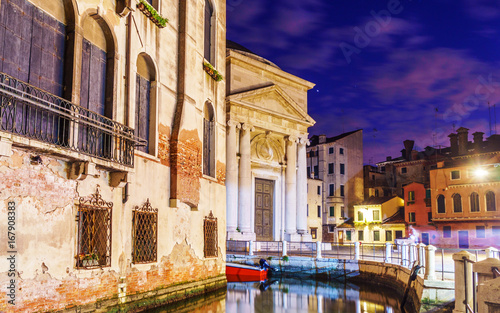 Night lights at Venice with typical Venetian buildings and canals with boats.