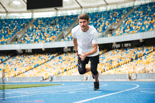 Young male athlete running on a racetrack