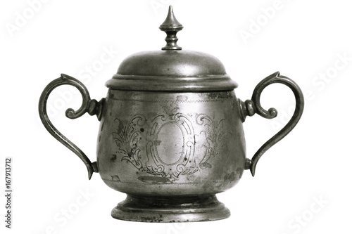 An old silver metal sugar bowl with a lid and ornament. Metal punctles with scratches and patina.