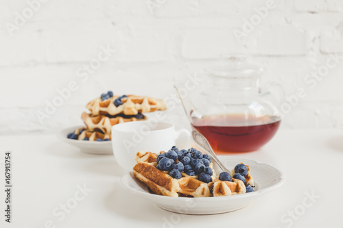 delicious breakfast of freshly baked waffles with blueberries and tea