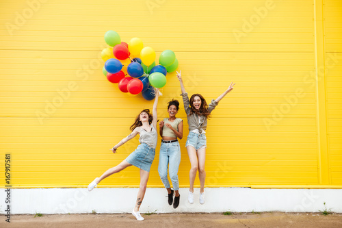 Happy women friends have fun with balloons.