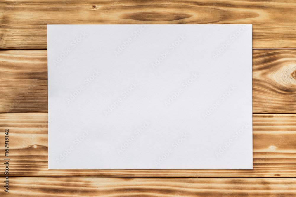 Mockup of white a4 paper list at textured wooden table background. Mockup of white a4 paper list at textured wooden table background.