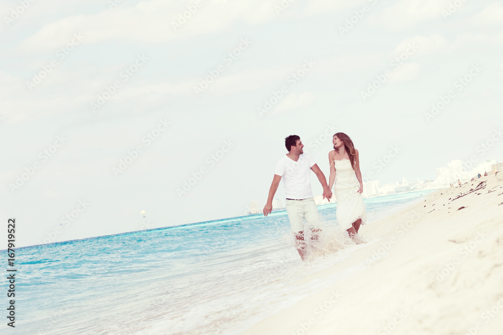 Young  beautiful newlyweds on white sandy beach