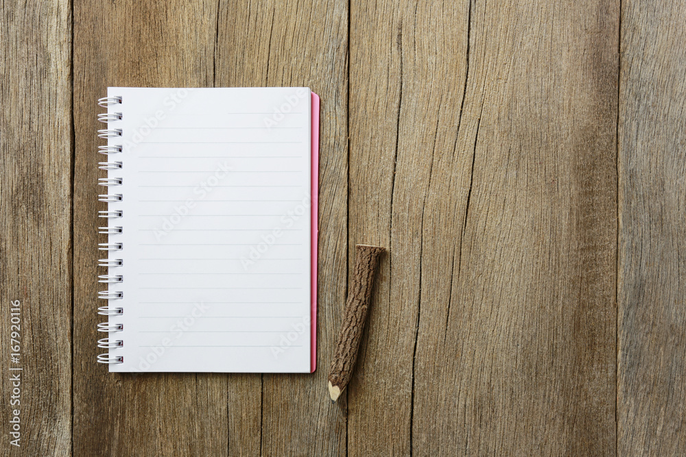 notepad book is placed on a brown wooden floor. notepad book is placed on a brown wooden floor.
