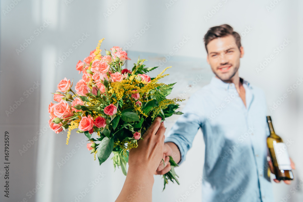 handsome man giving bouquet to his girlfriend handsome man giving bouquet to his girlfriend