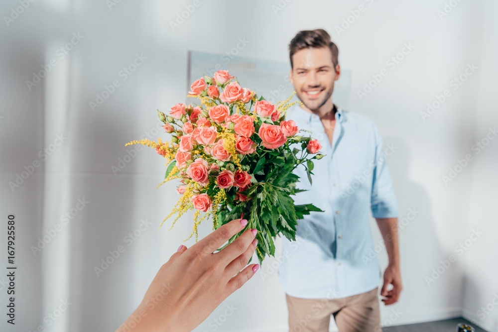 handsome man giving bouquet to his girlfriend handsome man giving bouquet to his girlfriend