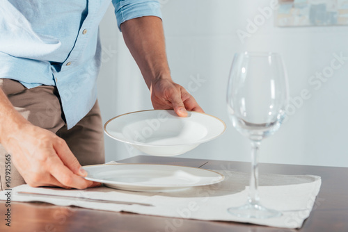 close-up shot of man serving table with plates