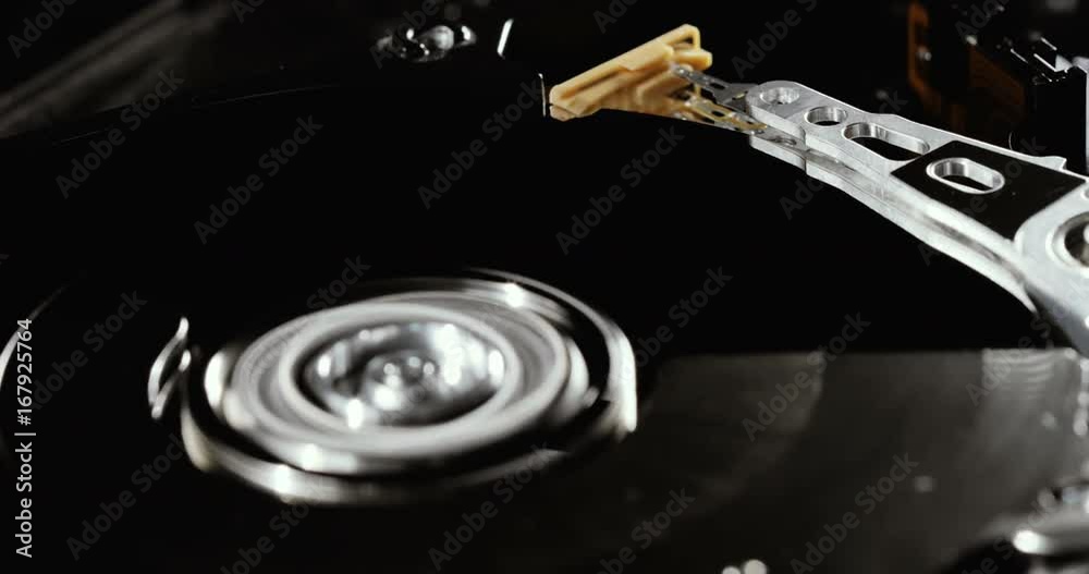 Operating hard disk drive on dark background. HDD reading and writing data.